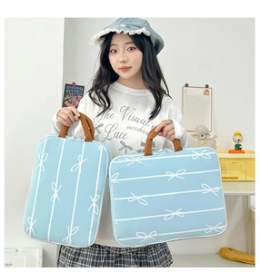 Close-up of light blue handbags with white bow patterns and brown handles in two sizes