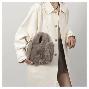 Detail of plush faux fur shoulder bag in dark grey with elegant gold chain strap
