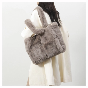 Détail d'un sac cabas en peluche grise à motif damier porté par un mannequin