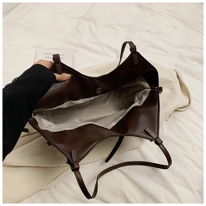 Detail view showing interior space of the brown PU tote bag with silver magnetic snap closure