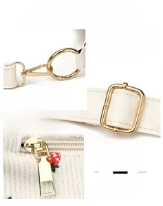 Close-up of golden hardware and white leather strap on a corduroy strawberry bag