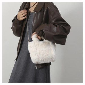 Detailed close-up of a white faux fur shoulder bag with an elegant golden chain strap