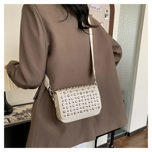 Detail view of cream PU leather crossbody bag with silver studs and wide strap