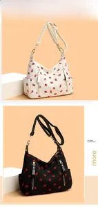 Detail of strawberry print corduroy shoulder bag with metal zipper and adjustable strap