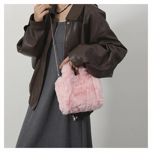 Detailed view of pink plush crossbody bag featuring faux fur texture and a metal chain strap