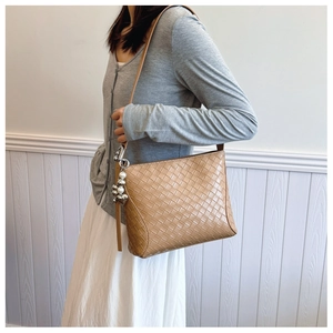 Detail of tan woven PU leather handbag featuring elegant pearl and metal ball charms