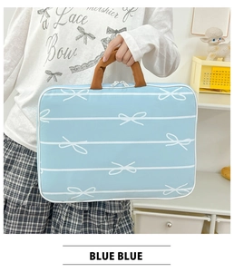 Detail of light blue bow pattern laptop sleeve with brown handles and white dual zippers