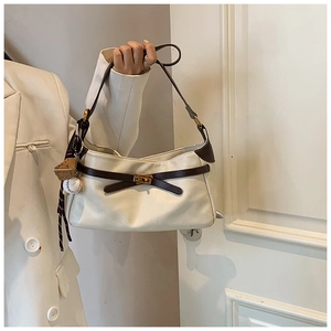 Detail of white PU shoulder bag with brown strap and sporty baseball glove charm