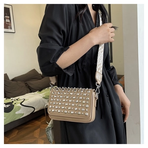 Close-up of khaki PU leather bag with silver rhinestones and woven geometric shoulder strap