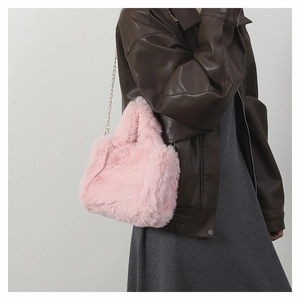 Detailed close-up of pink faux fur handbag texture with elegant metal chain strap