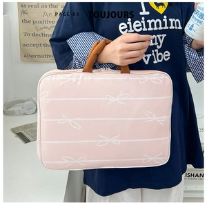 Pink canvas laptop sleeve featuring white stripes, bow patterns, and soft brown handles
