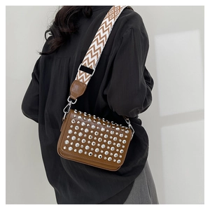 Detail view of brown PU leather crossbody bag with silver rhinestones and woven strap