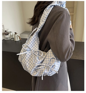 Detail of blue and white gingham fabric bag with sweet bow and wide shoulder strap