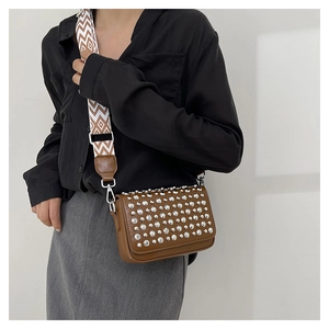 Detailed shot of brown PU leather crossbody bag with silver studs and ethnic strap