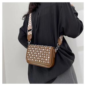Detail of a brown PU crossbody bag featuring silver stud accents and a geometric wide strap