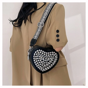 Détail du sac coeur en cuir PU avec rivets argentés et bandoulière géométrique