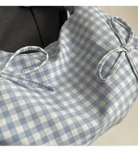 Detailed close-up of blue and white gingham fabric with a decorative bow detail