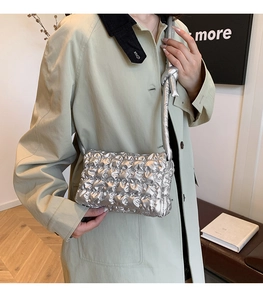 Detail der silbernen Metallic-Stepptasche mit modischem geknotetem Schulterriemendetail
