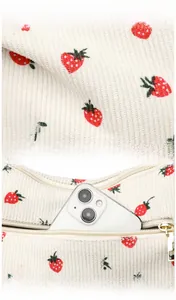 Detail of white corduroy fabric with strawberry print and functional back zipper pocket