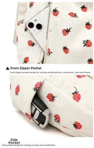 Detail of white corduroy crossbody bag featuring strawberry pattern and side storage pocket