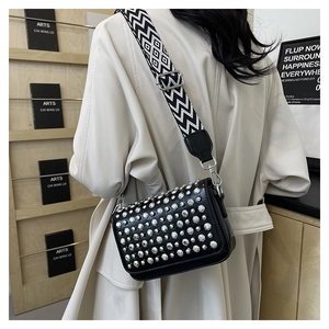 Detail view of black PU leather crossbody bag with silver studs and geometric strap