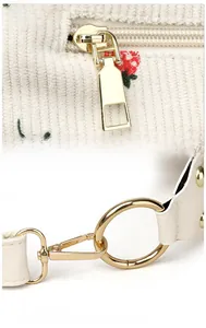 Detailed macro of gold metal zipper and strap ring on strawberry corduroy bag