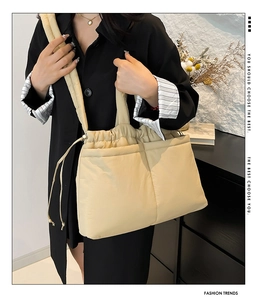 Close-up of beige quilted puffer tote bag with drawstring closure and soft nylon texture