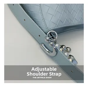 Detail of light blue woven PU leather bag with heart pearl charm and adjustable strap