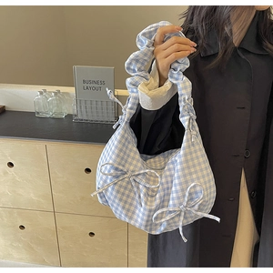 Detailed close-up of blue and white checkered fabric tote bag with cute decorative bows