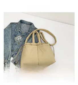 Top-down view of a beige quilted nylon tote bag with drawstring closure and wide strap