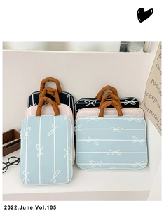 Detail of fabric tote bag featuring white stripes, bow print, and round brown handles