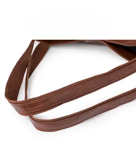 Close-up detail of the brown PU leather shoulder strap with durable fabric edging