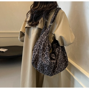 Detailed view of large leopard print tote bag with silver rings on the shoulder strap
