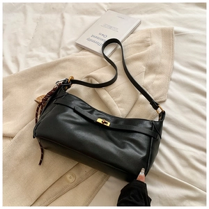 Minimalist black PU leather half-moon shoulder bag with a gold metal clasp and thin strap