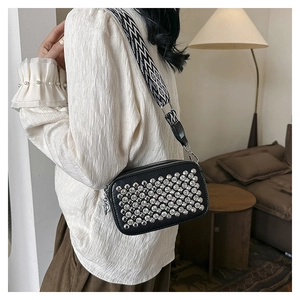 Chic black camera bag with sparkling silver studs and a geometric woven shoulder strap