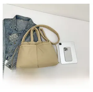Quilted beige puffer bag with drawstring closure next to an iPad for size comparison