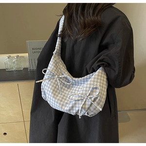 Close-up of blue and white gingham shoulder bag with two decorative bow accents