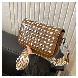 Brown PU leather shoulder bag with silver rivets and geometric woven strap in a modern setting