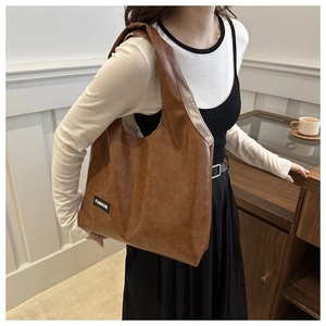 Close-up of vintage brown PU leather shoulder bag featuring a black Fashion woven label