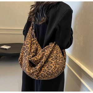 Close-up of stylish leopard print oversized tote bag worn by a model in a minimalist room