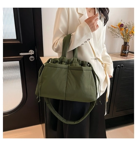 Detail of army green quilted tote bag showing cloud-like texture and drawstring closure