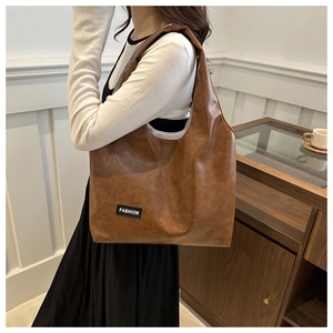 Close-up of brown PU leather tote bag featuring a minimalist Fashion label patch