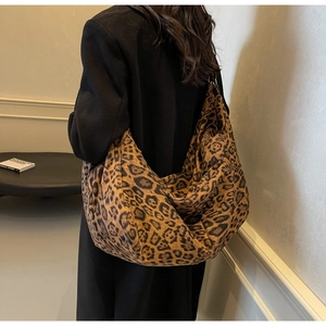 Detailed view of large leopard print PU leather hobo bag worn by a model in a minimalist room