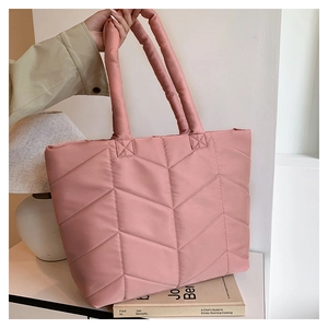 Detailed view of pink quilted nylon tote bag with chevron stitching and soft texture