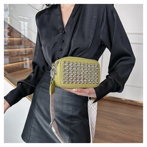 Detail of avocado green PU leather bag with silver studs and geometric jacquard strap