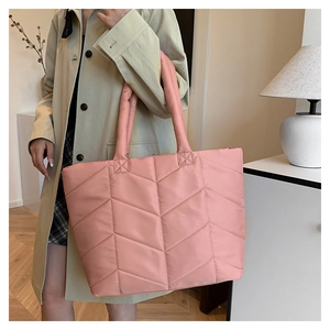Close-up of pink quilted nylon tote bag showing plush texture and V-shaped stitching detail
