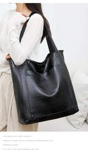 Close-up of a black PU leather tote bag with a unique geometric patchwork texture design
