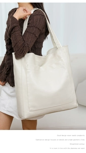 Detail of minimalist beige PU leather tote bag featuring geometric stitching and large pocket