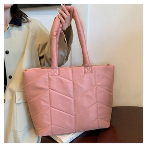 Detailed view of pink quilted nylon tote bag with V-shaped arrow feather stitching pattern