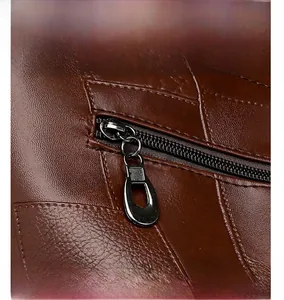 Detail view of the brown leather shoulder bag featuring metal zipper and fine stitching